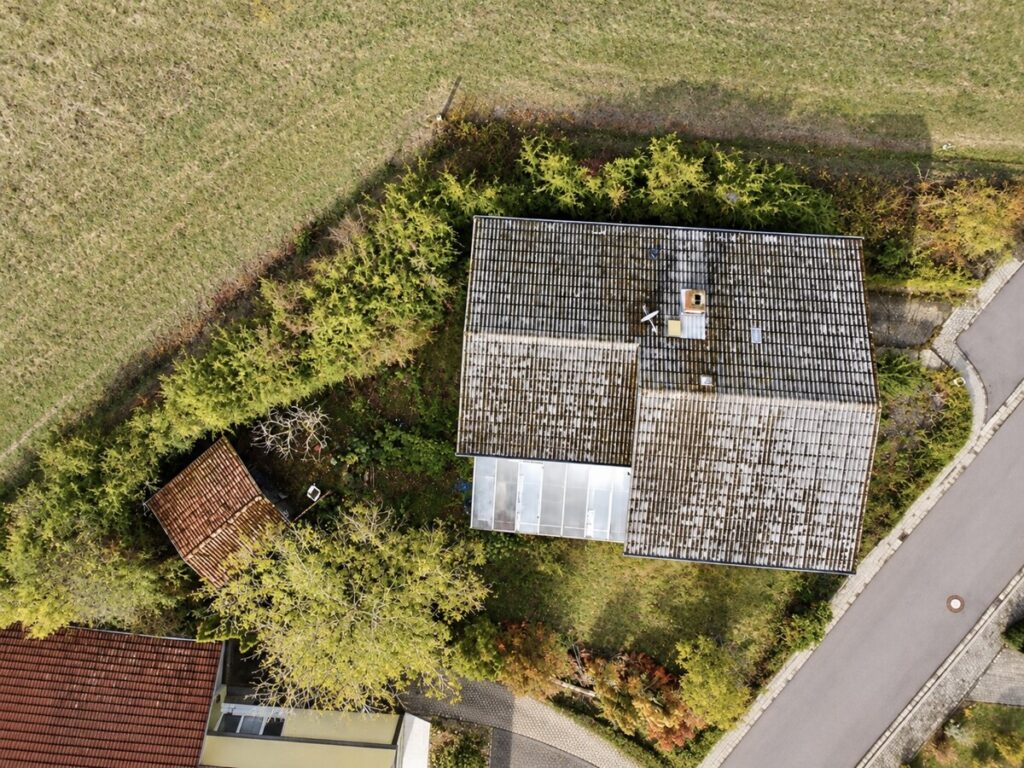 Drohnenansicht eines überwucherten Landhauses